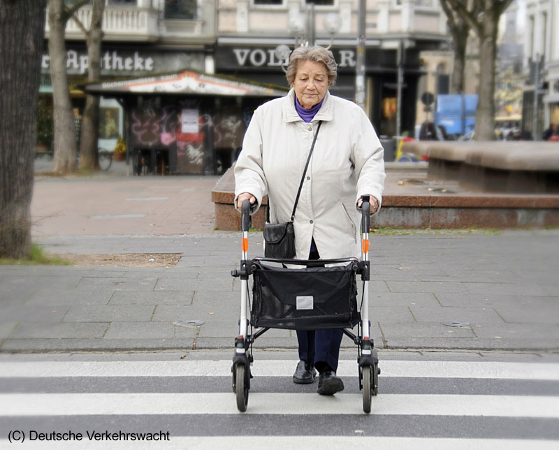 Seniorin mit Rollator am Zebrastreifen